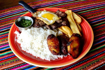 Carne a la plancha - Grilled Steak, a classic in most nations but Peruvians do it in style by topping it with a Chimichurri sauce and a fried egg. Served with fries, White Rice and Maduro Frito on the side.