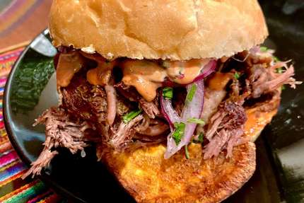 Sandwich de Chicharron - The Sandwich de Chicharrón combines thick slices of tender and juicy pork shoulder meat with Peru's most important salsa, the Salsa Criolla. These are stacked in between a crispy French roll and rounded off with slices of sweet potato making the Sanguche de Chicharrón the most typical combination of Peruvian flavors you ever tasted before in a simple sandwich. Absolutely delicious!