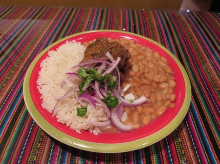 Seco a la Nortena - Thick beef cuts made in a cilantro sauce with aji Panca and served with Canario beans and White Rice and topped with Salsa Criolla.